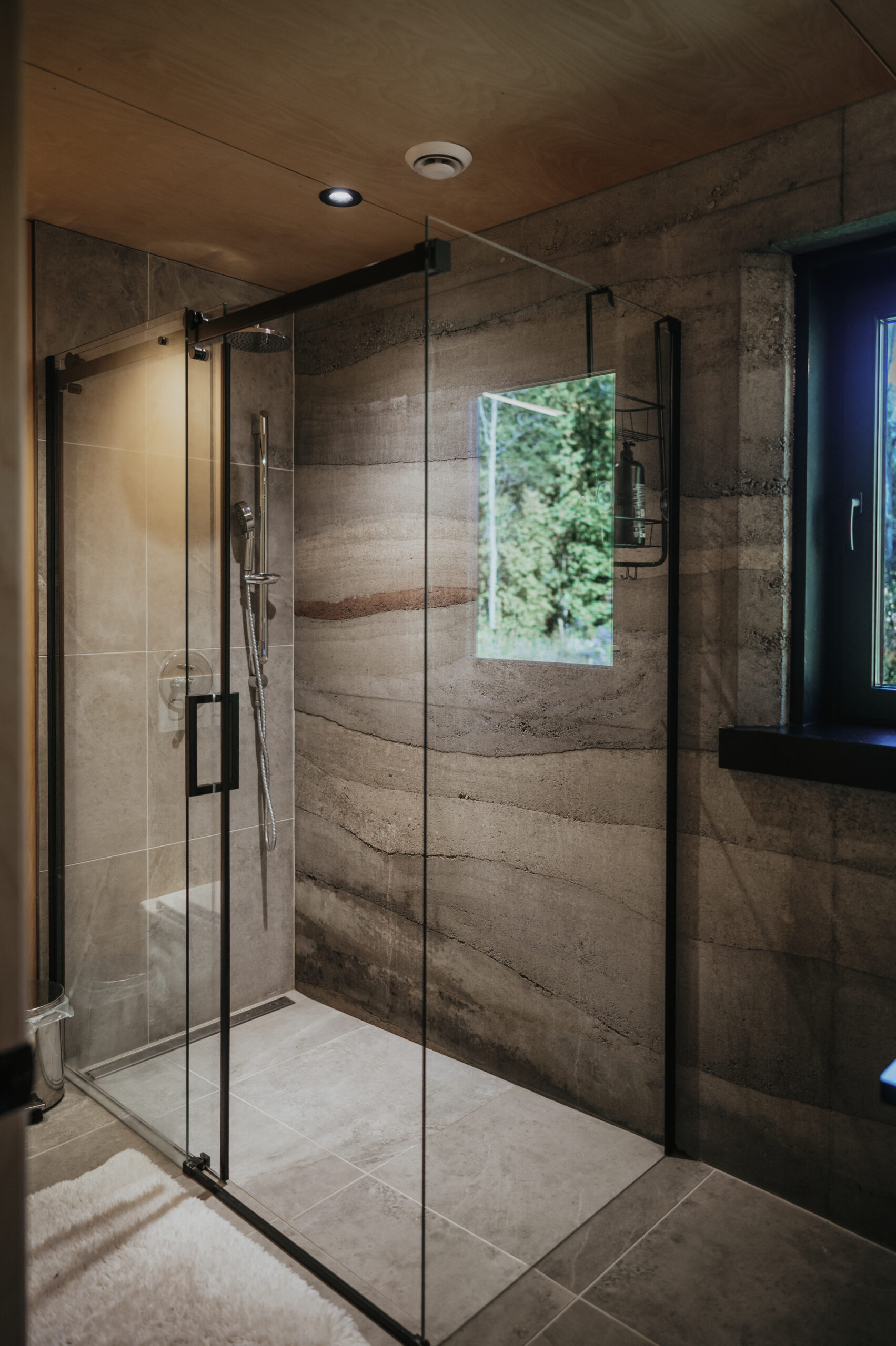 Rammed earth and glass shower with complementary Savon du Bois soaps